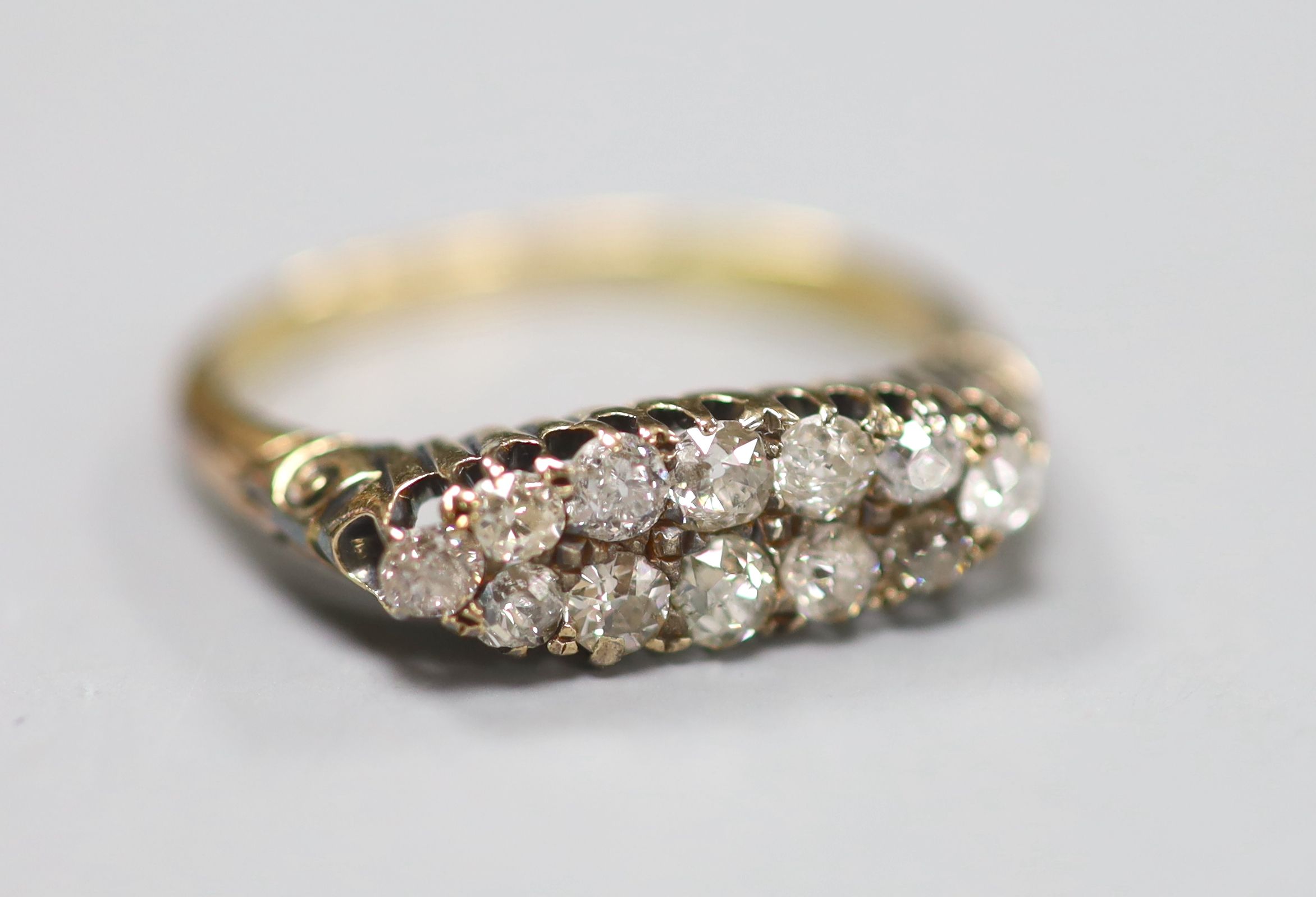 A yellow metal and two row twelve stone diamond set dress ring, size P, gross 2.6 grams.